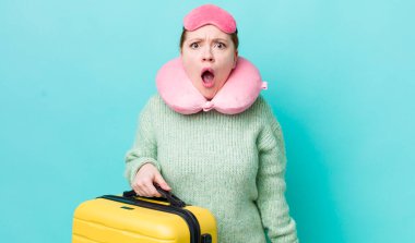 Kızıl saçlı güzel kadın çok şaşırmış ya da şaşkın görünüyor. uçuş yolcu kavramı