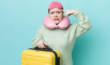 Kızıl saçlı güzel kadın kafası karışık ve şaşkın hissediyor, deli olduğunu gösteriyor. uçuş yolcu kavramı