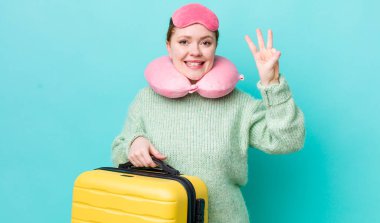 Kızıl saçlı güzel kadın gülümsüyor ve arkadaş canlısı görünüyor, üç numarayı gösteriyor. uçuş yolcu kavramı