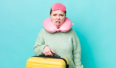 Kızıl saçlı güzel kadın iğrenmiş ve sinirlenmiş hissediyor ve dilini dışarı çıkarıyor. uçuş yolcu kavramı