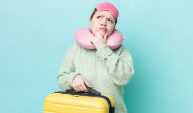 Kızıl saçlı güzel kadın düşünüyor, kuşkulu ve şaşkın hissediyor. uçuş yolcu kavramı