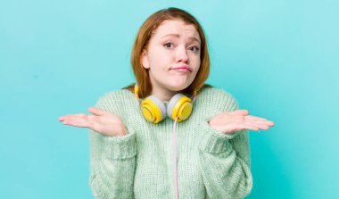 Kızıl saçlı güzel kadın şaşkın, şaşkın ve şüpheci hissediyor. Müzik konseptinin tadını