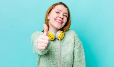 Kızıl saçlı güzel bir kadın gururlu, olumlu gülümsüyor. Müzik konseptinin tadını