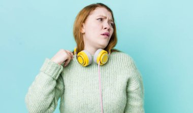 Kızıl saçlı güzel kadın stresli, endişeli, yorgun ve hayal kırıklığına uğramış hissediyor. Müzik konseptinin tadını