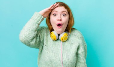 Kızıl saçlı güzel kadın mutlu, şaşkın ve şaşırmış görünüyor. Müzik konseptinin tadını