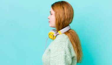 Profil bakışlı kızıl saçlı güzel kadın hayal mi kuruyor yoksa hayal mi kuruyor? Müzik konseptinin tadını