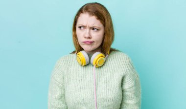 Kızıl saçlı, güzel bir kadın üzgün, üzgün ya da kızgın ve yana bakıyor. Müzik konseptinin tadını