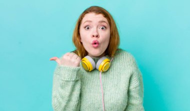 Kızıl saçlı, güzel bir kadın inançsızlıktan şaşkın şaşkın bakıyor. Müzik konseptinin tadını