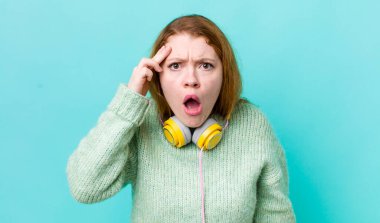 Kızıl saçlı güzel kadın şaşırmış görünüyor, yeni bir düşünce, fikir ya da konsept fark ediyor. Müzik konseptinin tadını