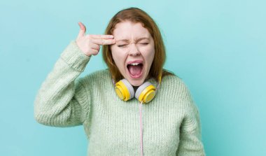 Kızıl saçlı güzel bir kadın mutsuz ve stresli görünüyor, intihar jesti silah işareti yapıyor. Müzik konseptinin tadını