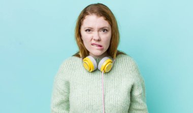 Kızıl saçlı güzel kadın kafası karışık ve şaşkın görünüyor. Müzik konseptinin tadını