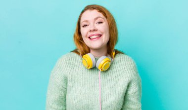 Kızıl saçlı güzel kadın mutlu ve hoş bir şekilde şaşırmış görünüyor. Müzik konseptinin tadını