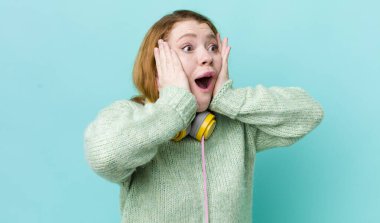 Kızıl saçlı güzel kadın mutlu, heyecanlı ve şaşırmış hissediyor. Müzik konseptinin tadını