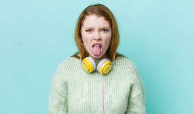 Kızıl saçlı güzel kadın iğrenmiş ve sinirlenmiş hissediyor ve dilini dışarı çıkarıyor. Müzik konseptinin tadını