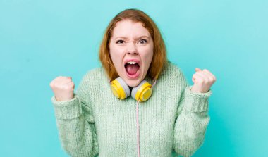 Kızıl saçlı güzel bir kadın sinirli bir ifadeyle agresif bir şekilde bağırıyor. Müzik konseptinin tadını