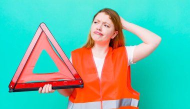 Kızıl saçlı güzel kadın mutlu bir şekilde gülümsüyor ve hayal kuruyor ya da şüphe ediyor. Araba üçgeni kazası.