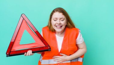 Kızıl saçlı güzel bir kadın komik bir şakaya yüksek sesle gülüyor. Araba üçgeni kazası.