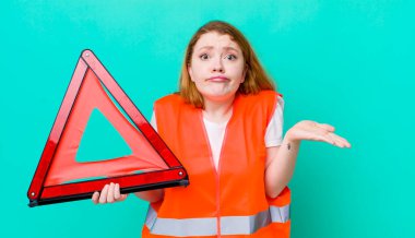 Kızıl saçlı güzel kadın şaşkın, şaşkın ve şüpheci hissediyor. Araba üçgeni kazası.