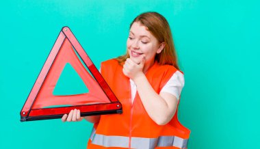 Kızıl saçlı, güzel bir kadın mutlu, kendinden emin, elleri çenesinde gülümsüyor. Araba üçgeni kazası.