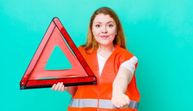 Kızıl saçlı, güzel bir kadın arkadaşça gülümsüyor ve bir konsept sunuyor. Araba üçgeni kazası.