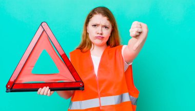 Kızıl saçlı, güzel bir kadın kendini kötü hissediyor, baş parmağını kaldırıyor. Araba üçgeni kazası.