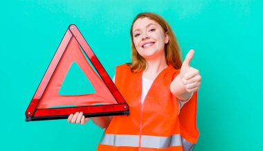 Kızıl saçlı güzel bir kadın gururlu, olumlu gülümsüyor. Araba üçgeni kazası.