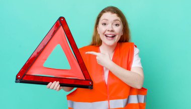 Kızıl saçlı, güzel bir kadın heyecanlı ve şaşırmış görünüyor. Araba üçgeni kazası.