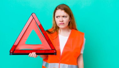 Kızıl saçlı, güzel bir kadın üzgün, üzgün ya da kızgın ve yana bakıyor. Araba üçgeni kazası.