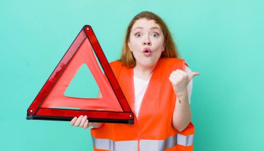 Kızıl saçlı, güzel bir kadın inançsızlıktan şaşkın şaşkın bakıyor. Araba üçgeni kazası.