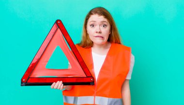 Kızıl saçlı güzel kadın kafası karışık ve şaşkın görünüyor. Araba üçgeni kazası.