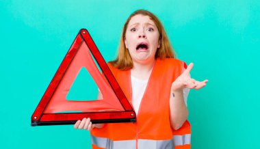 Kızıl saçlı güzel kadın umutsuz, hayal kırıklığına uğramış ve stresli görünüyor. Araba üçgeni kazası.