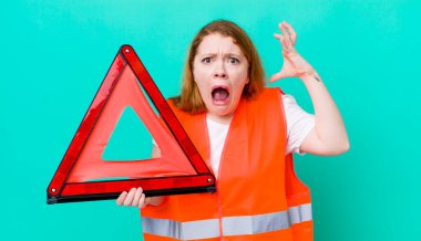 Kızıl saçlı güzel kadın ellerini havaya kaldırarak çığlık atıyor. Araba üçgeni kazası.