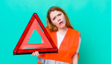 Kızıl saçlı güzel kadın şaşkın ve şaşkın hissediyor. Araba üçgeni kazası.