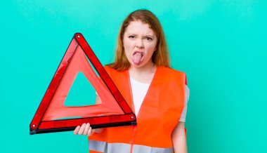 Kızıl saçlı güzel kadın iğrenmiş ve sinirlenmiş hissediyor ve dilini dışarı çıkarıyor. Araba üçgeni kazası.