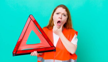 Kızıl saçlı, ağzı ve gözleri açık, eli çenesinde güzel bir kadın. Araba üçgeni kazası.