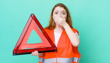 Kızıl saçlı, güzel bir kadın elleri ile ağzını kapatıyor. Araba üçgeni kazası.