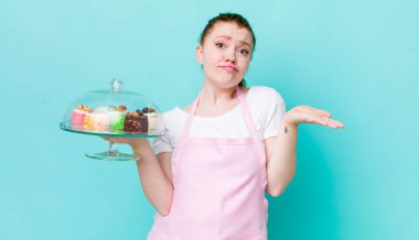 Kızıl saçlı güzel kadın şaşkın, şaşkın ve şüpheci hissediyor. Ev yapımı kek konsepti