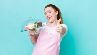 Kızıl saçlı güzel bir kadın gururlu, olumlu gülümsüyor. Ev yapımı kek konsepti