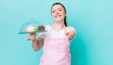 Kızıl saçlı güzel kadın kamerayı işaret ederek seni seçiyor. Ev yapımı kek konsepti