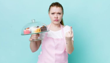 Kızıl saçlı güzel bir kadın kızgın, sinirli, asi ve agresif hissediyor. Ev yapımı kek konsepti