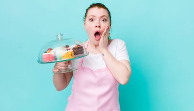 Kızıl saçlı güzel kadın şok olmuş ve korkmuş hissediyor. Ev yapımı kek konsepti