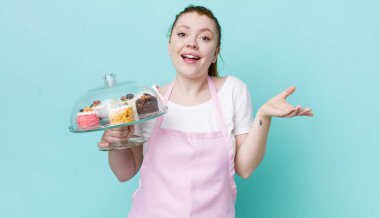 Kızıl saçlı güzel kadın kendini mutlu hissediyor, bir çözüm ya da fikir bulduğuna şaşırıyor. Ev yapımı kek konsepti