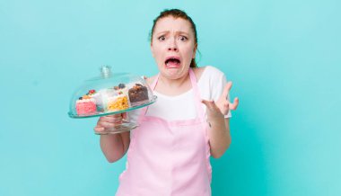 Kızıl saçlı güzel kadın umutsuz, hayal kırıklığına uğramış ve stresli görünüyor. Ev yapımı kek konsepti