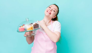 Kızıl saçlı güzel bir kadın kendini mutlu hissediyor ve bir meydan okumayla yüzleşiyor ya da kutluyor. Ev yapımı kek konsepti