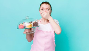 Kızıl saçlı, güzel bir kadın elleri ile ağzını kapatıyor. Ev yapımı kek konsepti