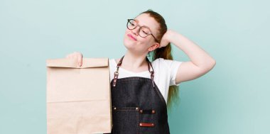 Kızıl saçlı güzel kadın şaşkın ve kafası karışık, kaşınan bir kafa hissediyor. teslimat kavramını kaldır