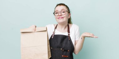 Kızıl saçlı güzel kadın şaşkın, şaşkın ve şüpheci hissediyor. teslimat kavramını kaldır