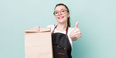 Kızıl saçlı güzel bir kadın gururlu, olumlu gülümsüyor. teslimat kavramını kaldır