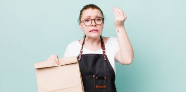 Kızıl saçlı, güzel bir kadın kapiş ya da para hareketi yapıyor, sana ödemeni söylüyor. teslimat kavramını kaldır