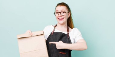 Kızıl saçlı, güzel bir kadın heyecanlı ve şaşırmış görünüyor. teslimat kavramını kaldır